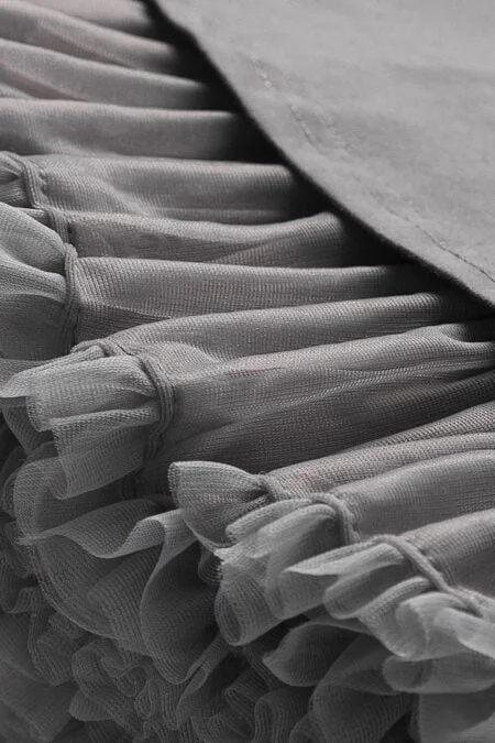Falda de tul gris para niñas con volantes suaves y detalle de capas.