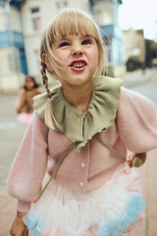 Niña vestida con falda de tul blanco y cuello decorativo verde