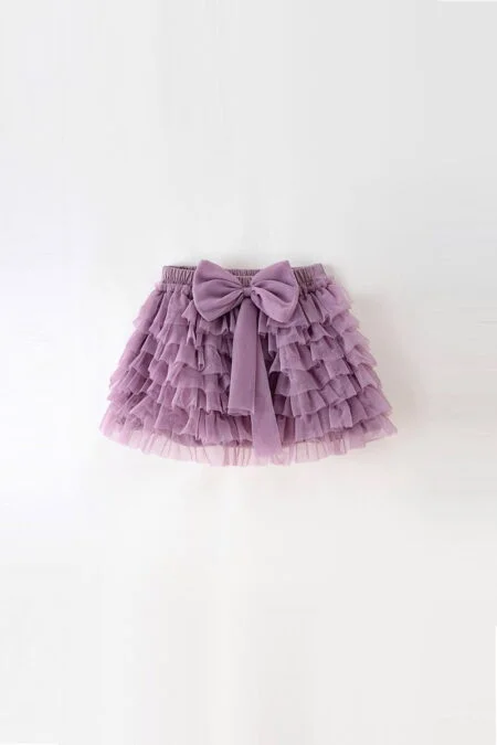 Gonna a balze lilla per bambine con fiocco decorativo. Leggera e morbida, ideale per look giocosi.