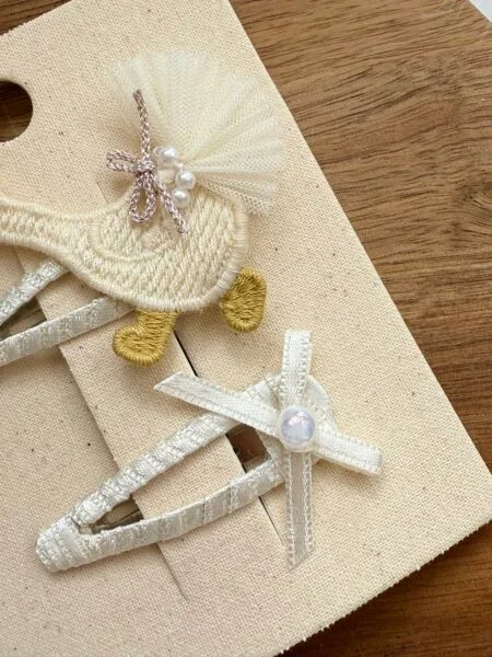 Set of pins for a girl in cream color with embroidery and tulle tail, decorated with pearls.