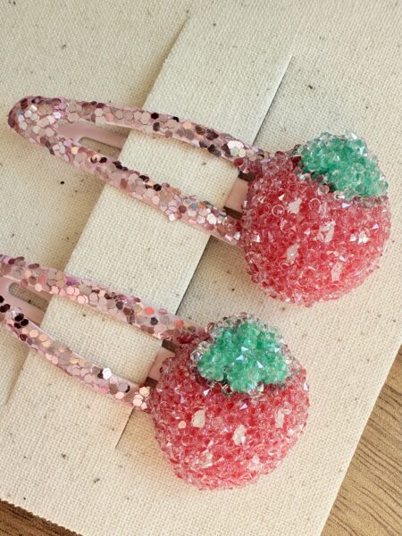 Haarspangen für Mädchen in Form von Erdbeeren, in rosa mit grünen Akzenten.
