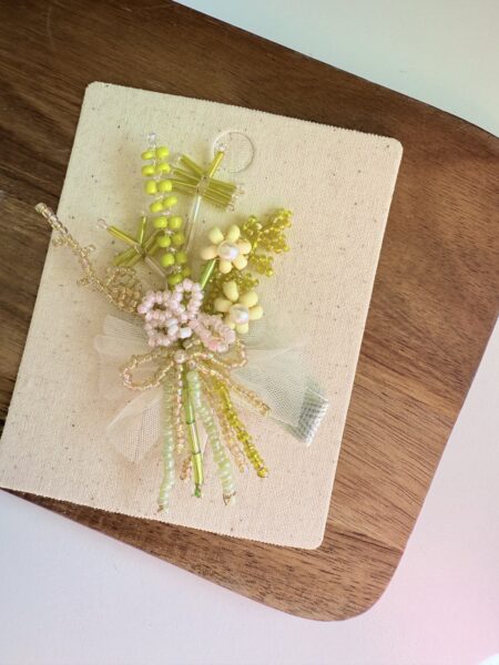 Una spilla per bambina con fiori di perline gialle in tonalità pastello. - Fermacapelli