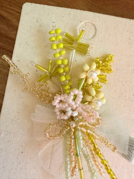 Pin with yellow flowers, beads and tulle, decoration for a girl.