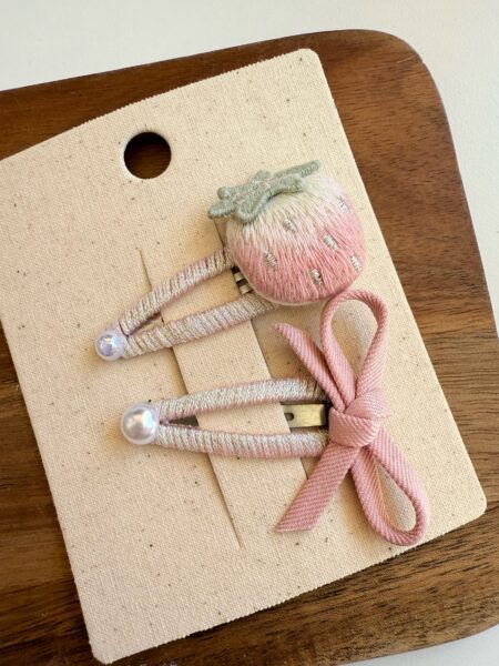 Set di spille con fiocco rosa e fragola per bambina, con dettagli in perle. - Fermacapelli