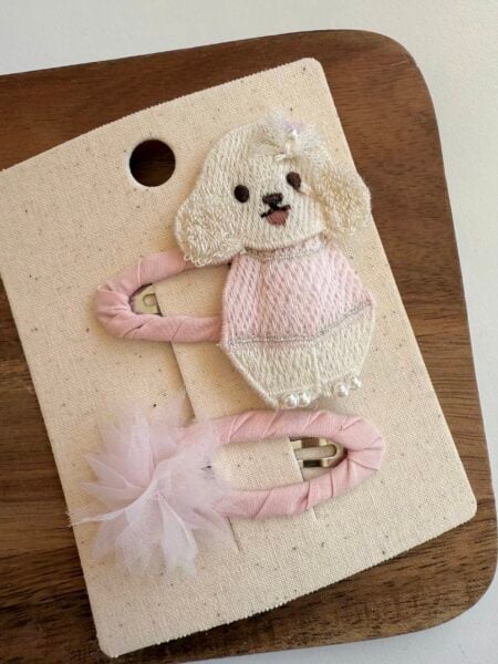 Clip per bambina con un cucciolo ricamato nei toni del beige e del rosa e un fiore delicato. - Fermacapelli