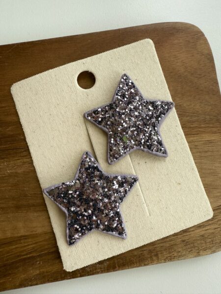 Pinzas para el pelo con forma de estrella de purpurina para niñas en color lila con destellos.